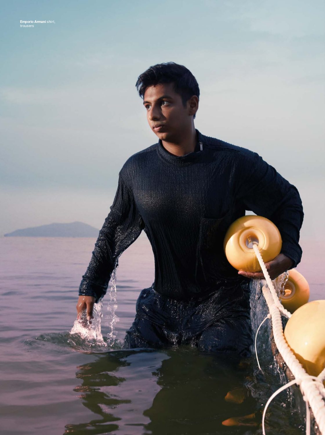 Sidhant Gupta standing in the sea with a robot